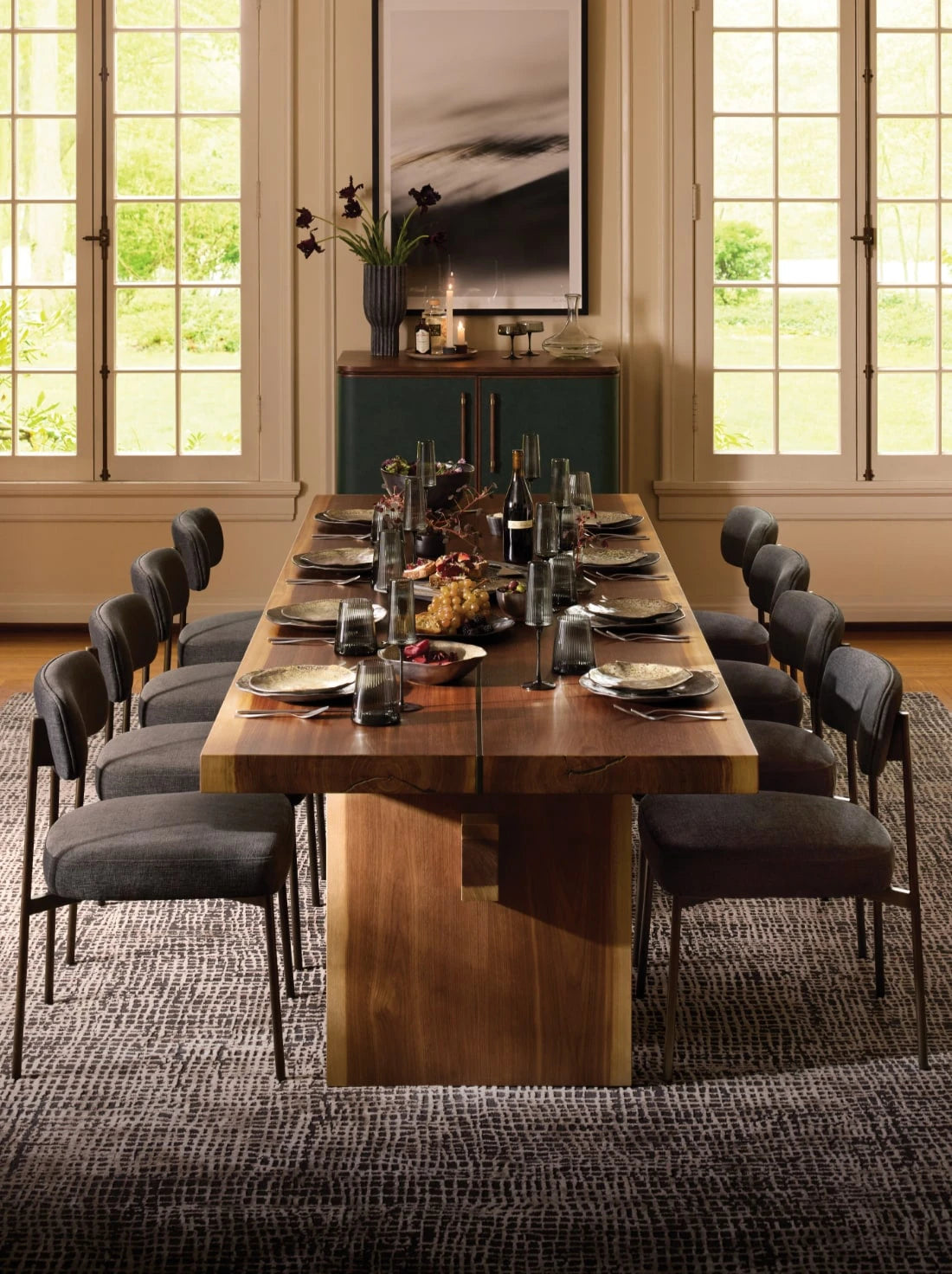 Warm wood dining table fully set for a dinner party.