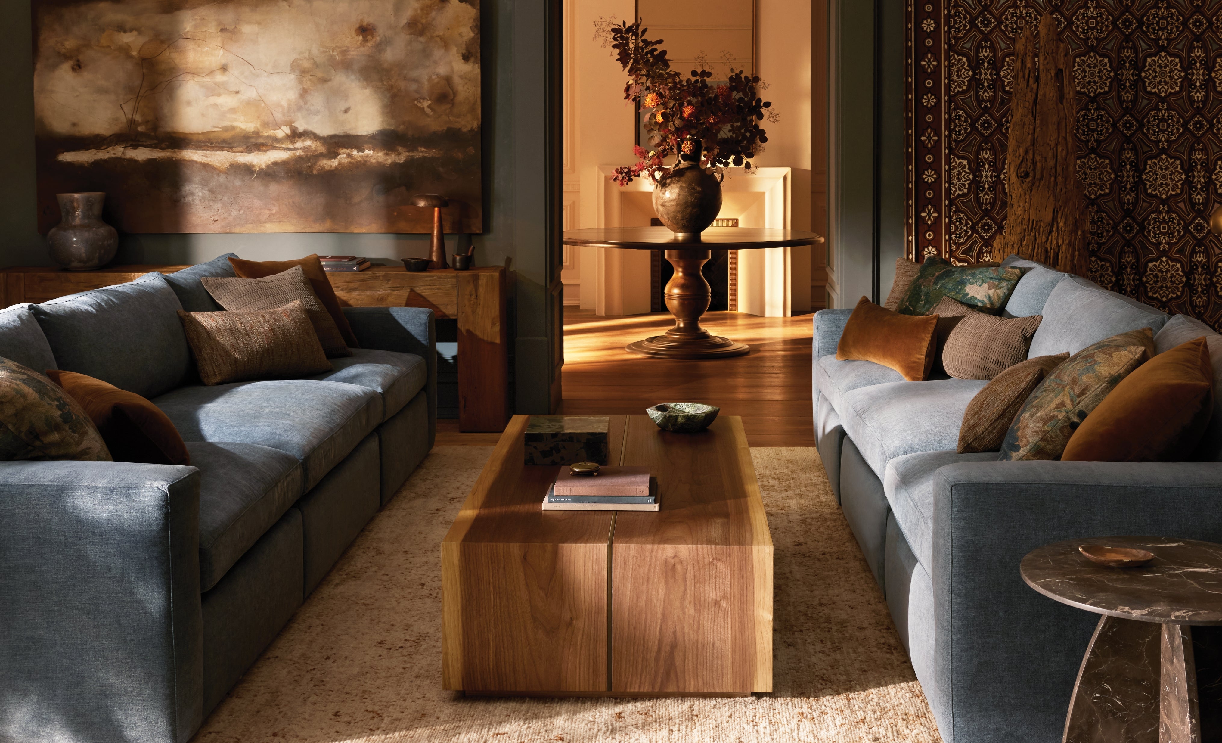 Modern living room with gray sofas, wooden coffee table, and decorative elements.